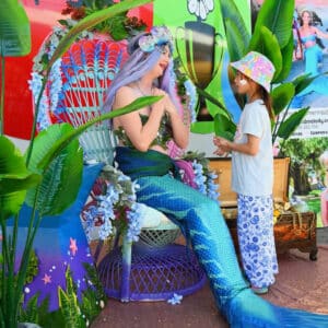 A mermaid performer talking to a child at a corporate event