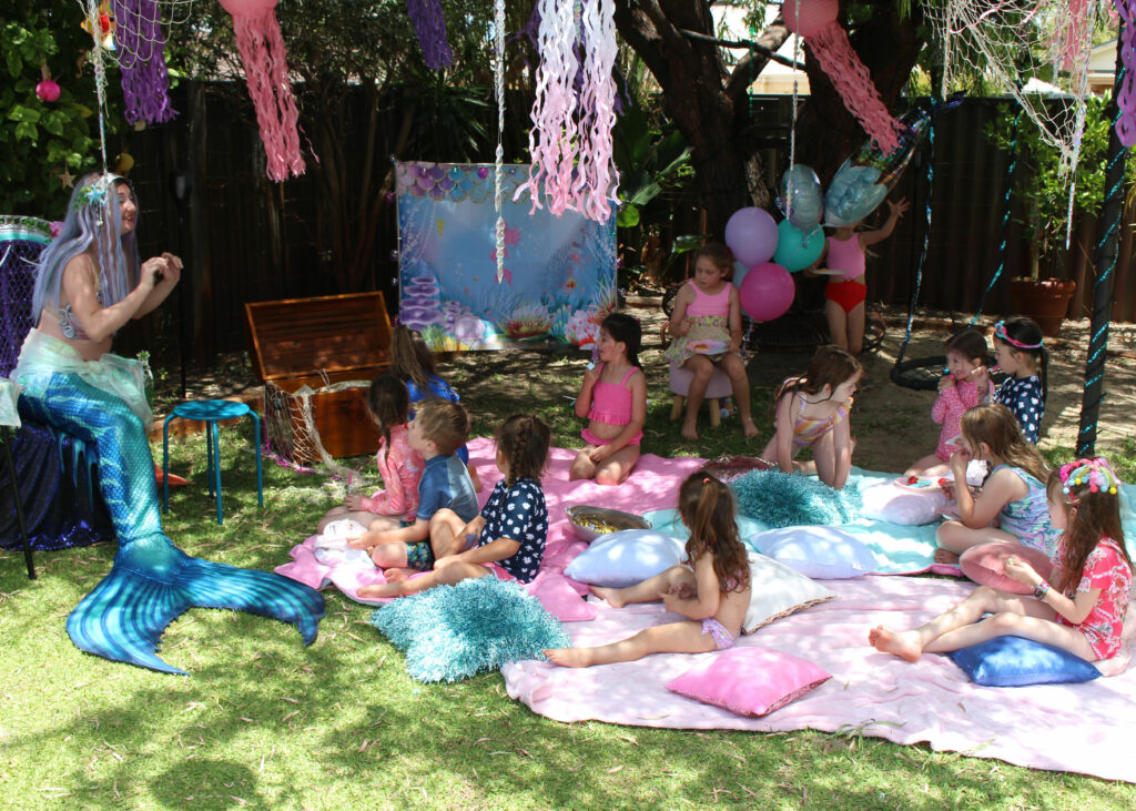 a mermaid performer singing songs at a children's birthday party