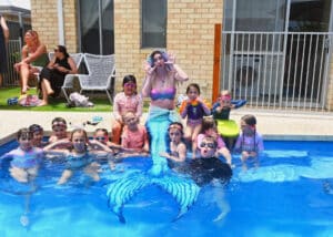 A mermaid performer in the pool at a children's party